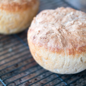 photo of two homemade bread loaves cooling on a rack