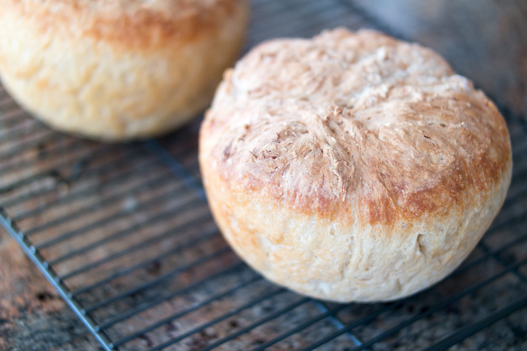 photo of two homemade bread loaves cooling on a rack