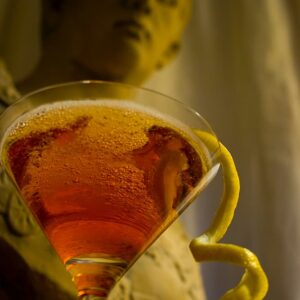 The Ashley Wilkes cocktail in a martini glass in front of a bust of Augustus Caesar