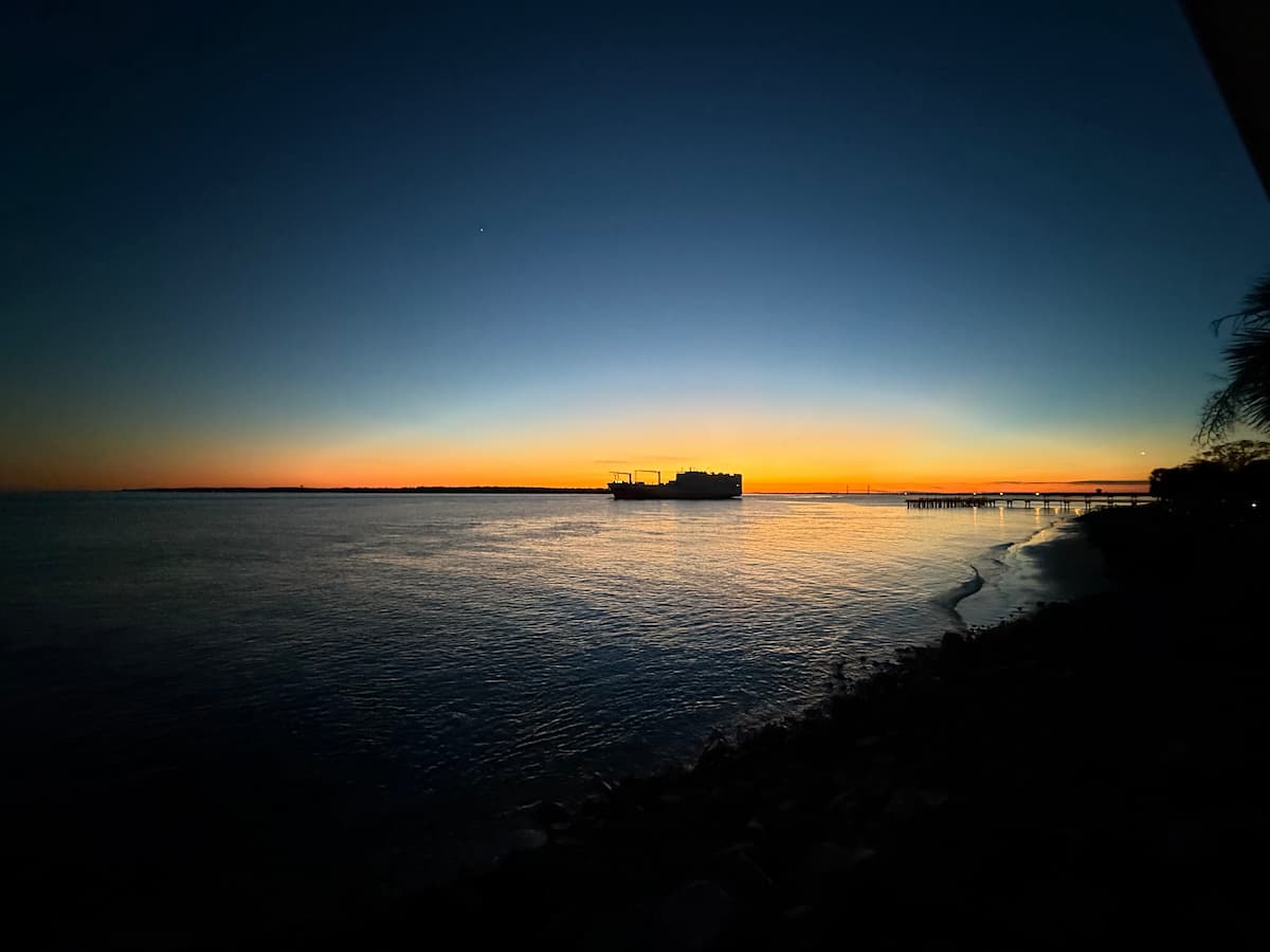 Sunset on St Simons Island with the pier and a sihoulette of a cargo ship